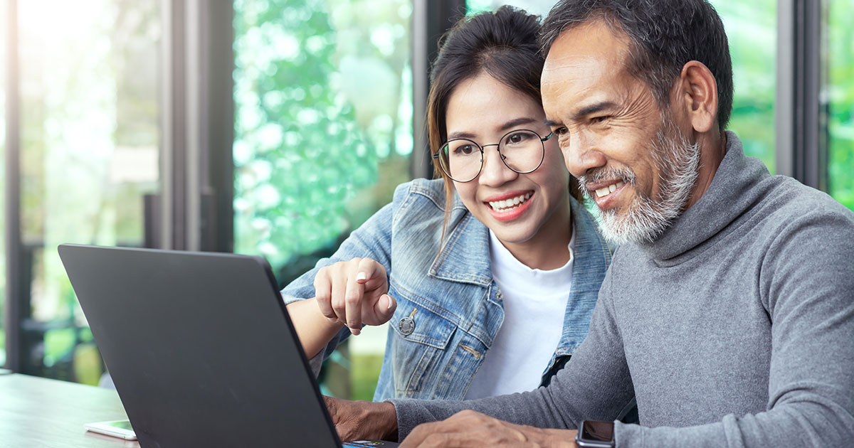two people looking at a laptop